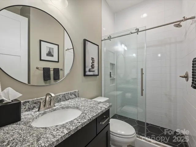 a bathroom with a granite countertop sink mirror toilet and shower