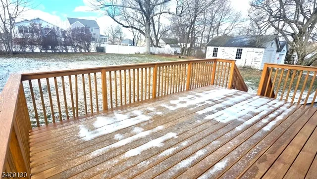 a view of backyard with wooden floor and fence