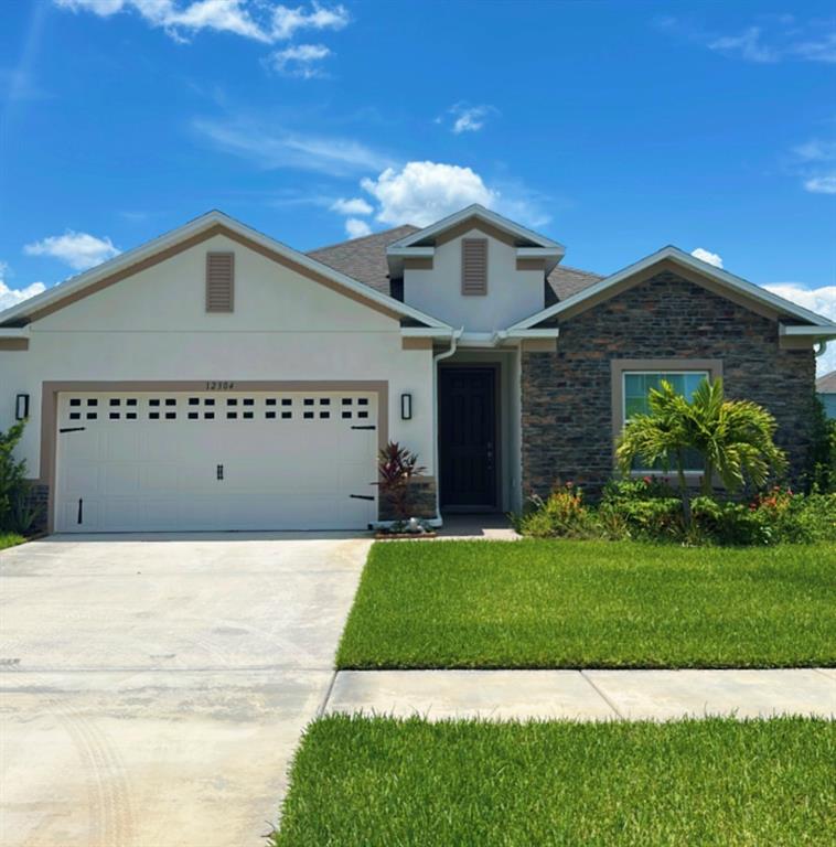 12304 Southwest Forli Way Port St. Lucie, FL 34987 - Photo 1 of 26 a front view of a house with a yard