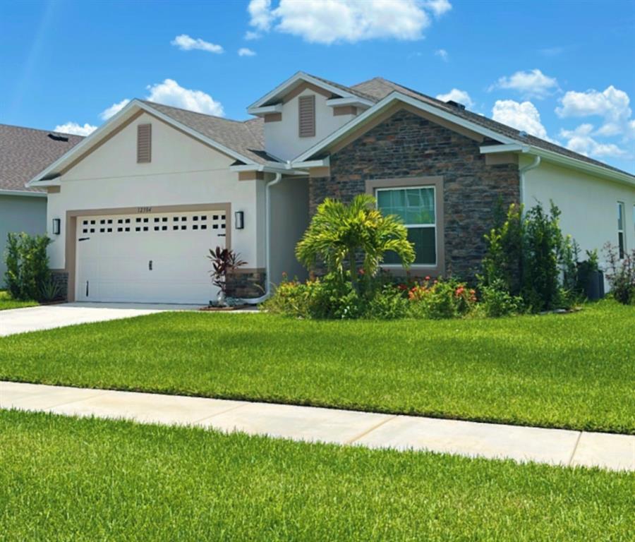 12304 Southwest Forli Way Port St. Lucie, FL 34987 - Photo 3 of 26 a front view of a house with a garden and plants