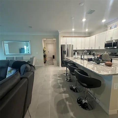 a kitchen with a sink a counter and chairs