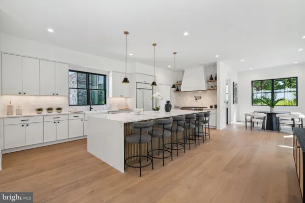 a kitchen with kitchen island granite countertop a sink cabinets and wooden floor