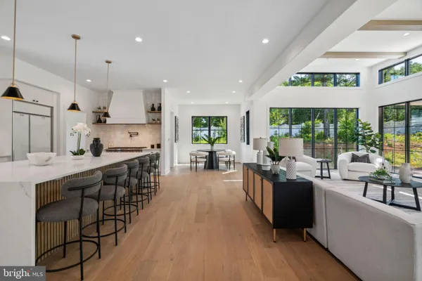 a living room with stainless steel appliances granite countertop lots of wooden furniture large window and wooden floor
