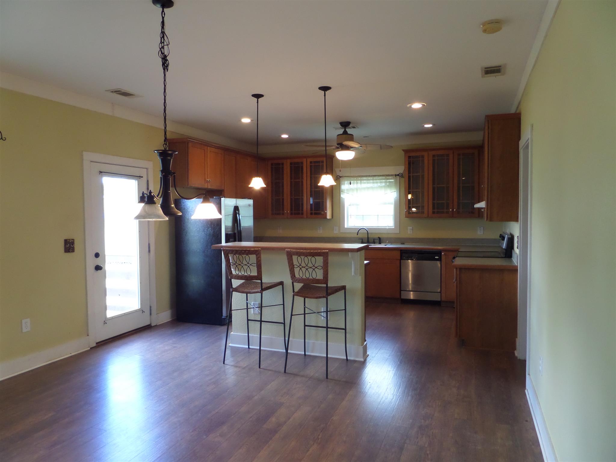 855 Cut Off Road Pulaski, TN 38478 - Photo 8 of 26 a kitchen with stainless steel appliances granite countertop a refrigerator a sink dishwasher a stove and a dining table with wooden floor