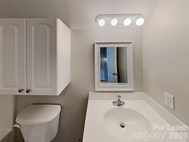 a bathroom with a toilet a sink and mirror