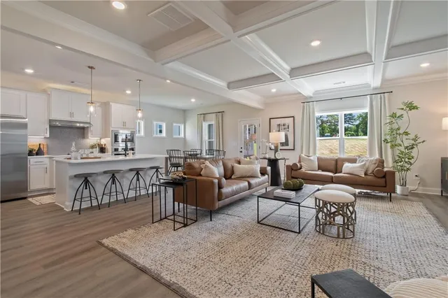 a kitchen with stainless steel appliances kitchen island granite countertop a dining table chairs and white cabinets