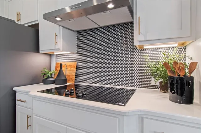 a dining room with stainless steel appliances kitchen island granite countertop a dining table chairs and a refrigerator