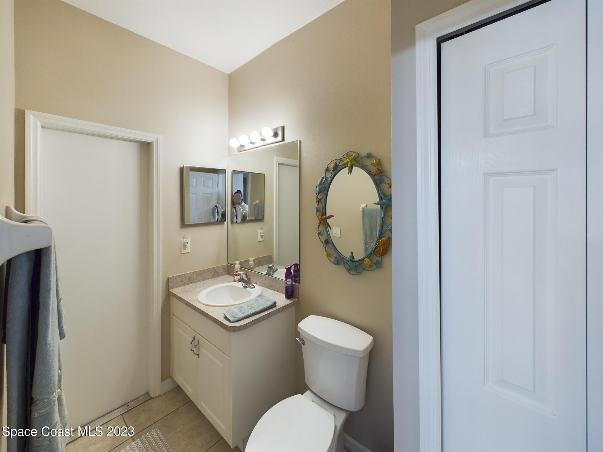 4630 Paladin Circle Vero Beach, FL 32967 - Photo 11 of 33 a bathroom with a granite countertop toilet sink and mirror