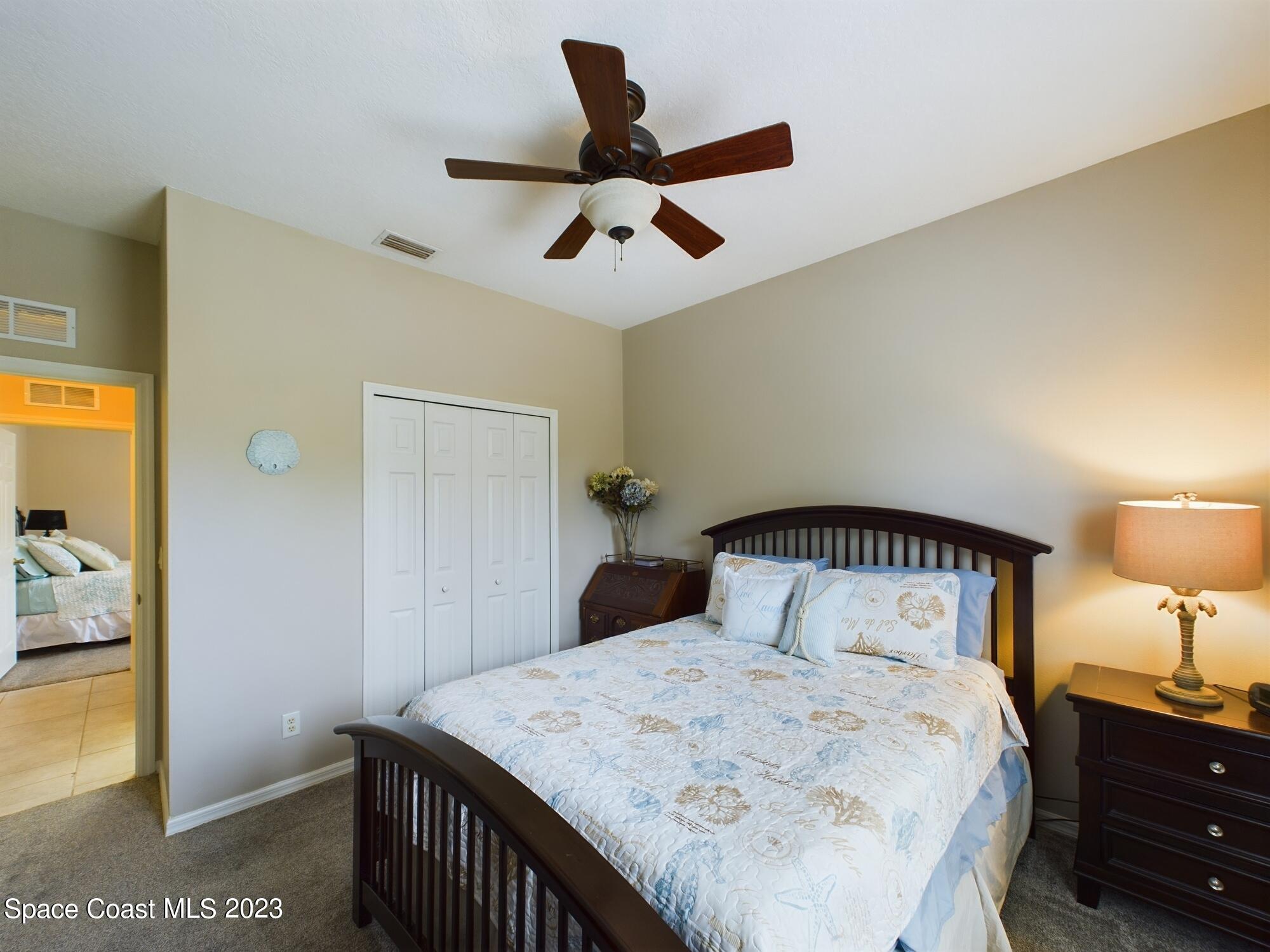 4630 Paladin Circle Vero Beach, FL 32967 - Photo 22 of 33 a bedroom with a bed and a lamp on the dresser
