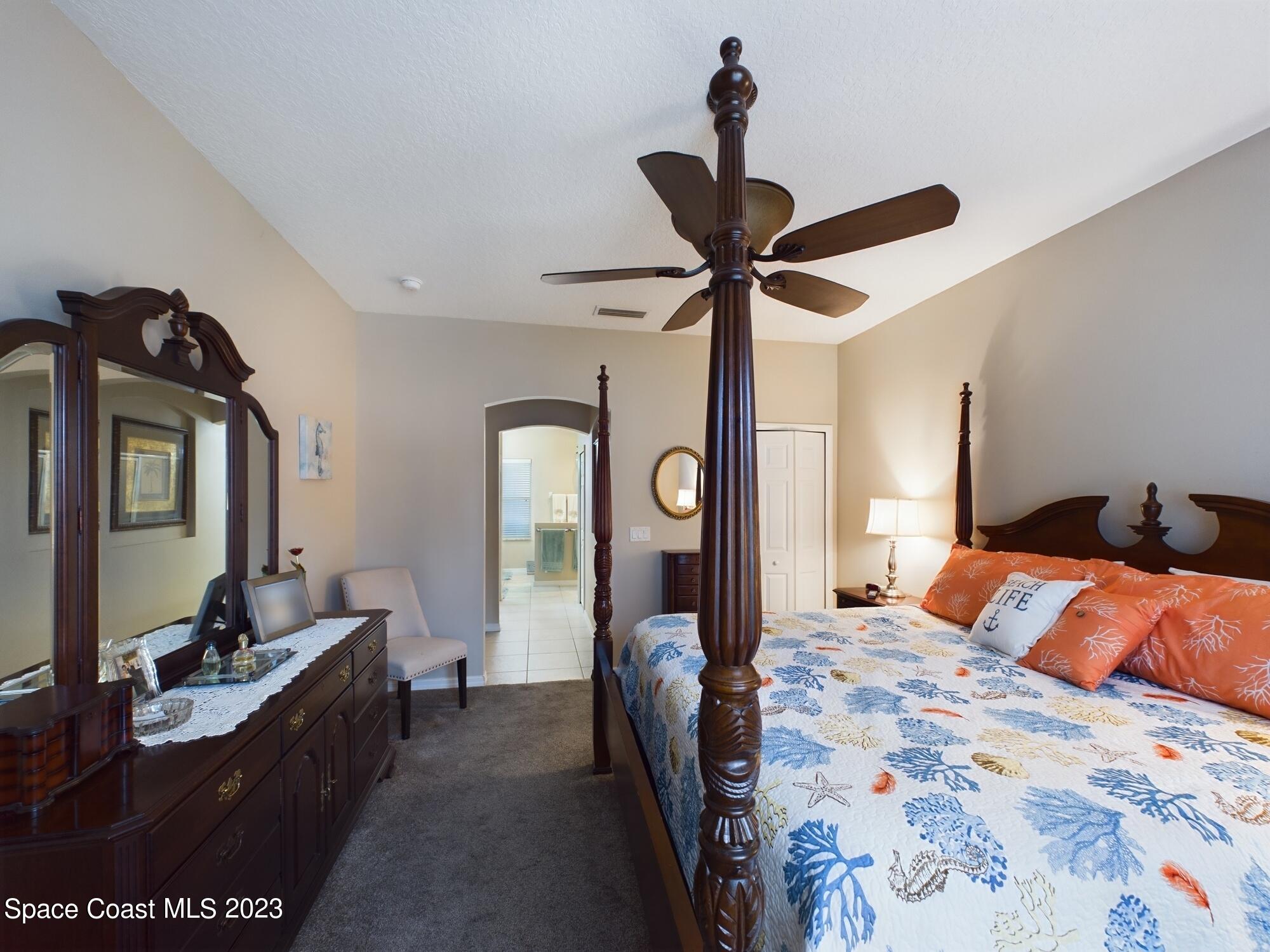 4630 Paladin Circle Vero Beach, FL 32967 - Photo 5 of 33 a bedroom with a bed a chandelier and dresser