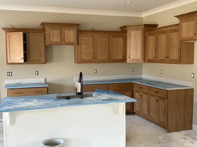 a kitchen with granite countertop a sink a stove and cabinets