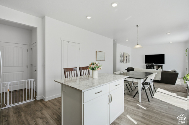1113 South Raintree Lane Santaquin, UT 84655 - Photo 23 of 59 Kitchen island with a light-toned countertop, white cabinetry with silver hardware, and wood-finish flooring
