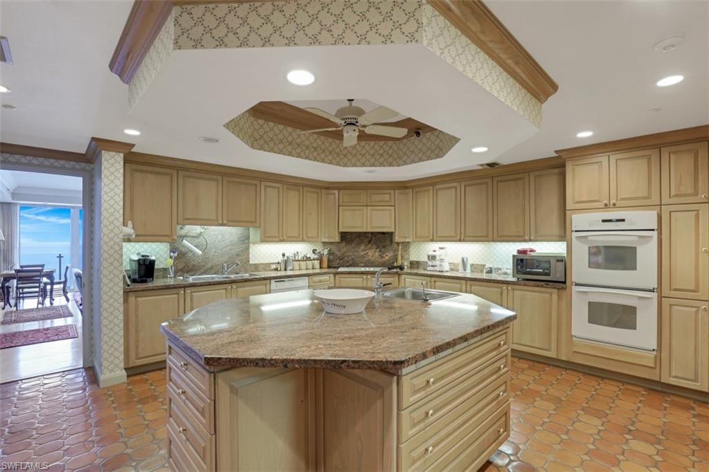 10 Seagate Drive, Unit 6S Naples, FL 34103 - Photo 16 of 34 a kitchen with stainless steel appliances granite countertop a sink a stove and a refrigerator