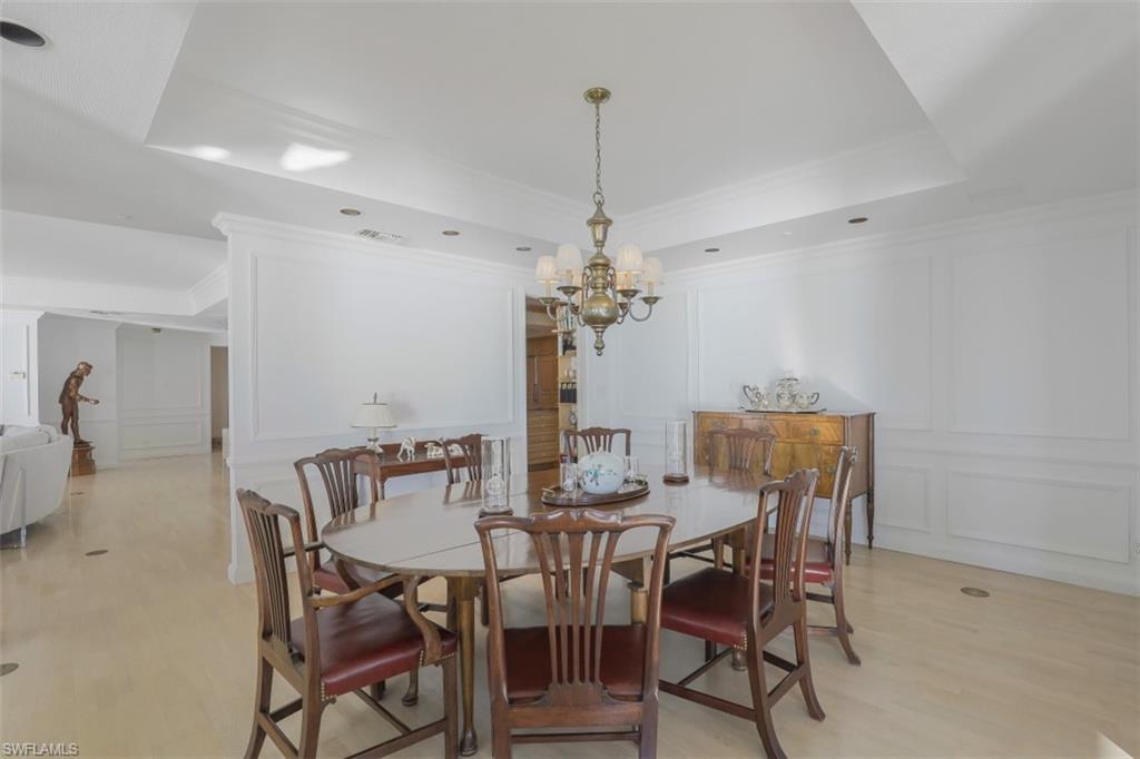 10 Seagate Drive, Unit 6S Naples, FL 34103 - Photo 18 of 34 a view of a dining room with furniture and chandelier