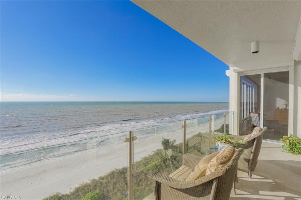 10 Seagate Drive, Unit 6S Naples, FL 34103 - Photo 2 of 34 a view of balcony with furniture and umbrella