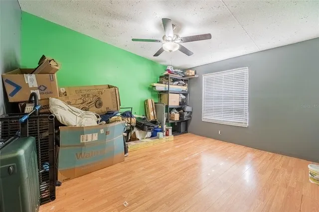 a bedroom with a bed and dresser with wooden floor