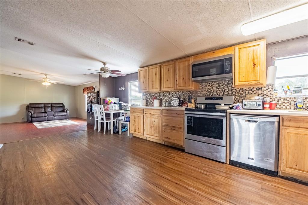 194 North Lake Patrick Road Babson Park, FL 33827 - Photo 8 of 31 a kitchen with stainless steel appliances a stove top oven a sink dishwasher and a refrigerator with wooden floor