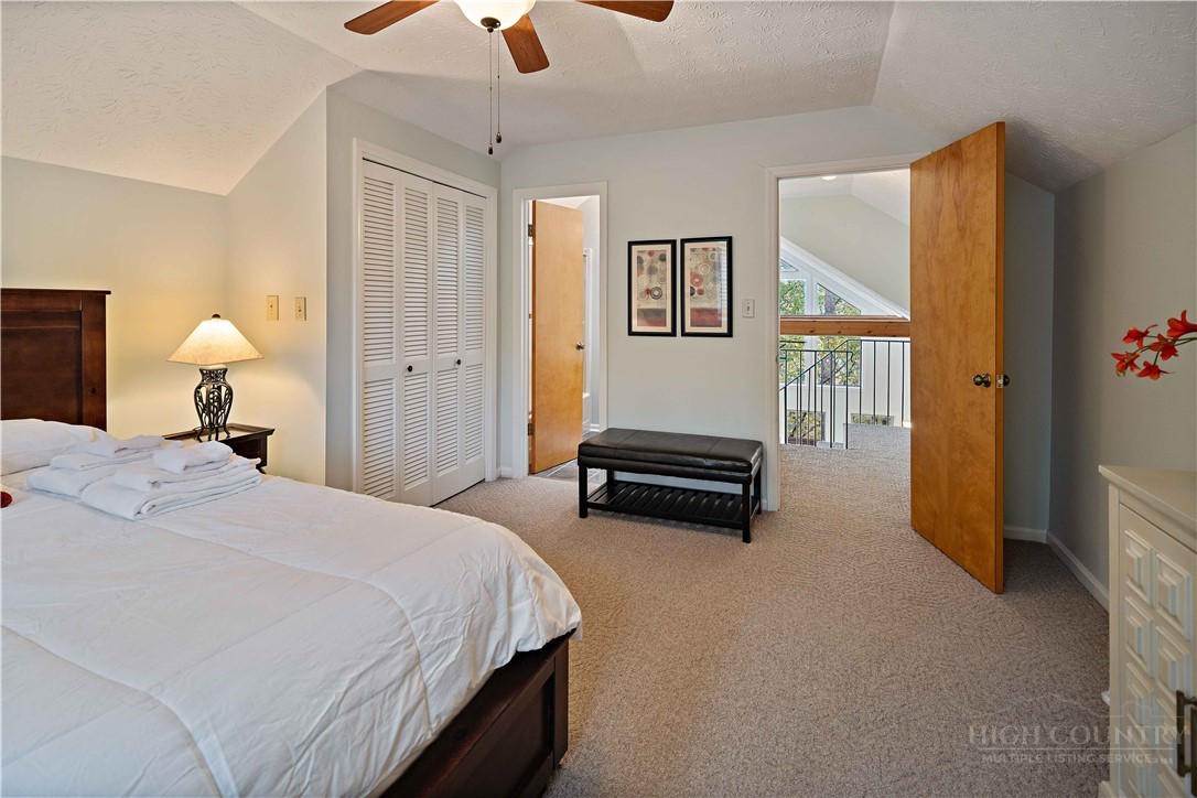 265 Leatherwood Road Banner Elk, NC 28604 - Photo 26 of 42 a bedroom with a bed and a chandelier