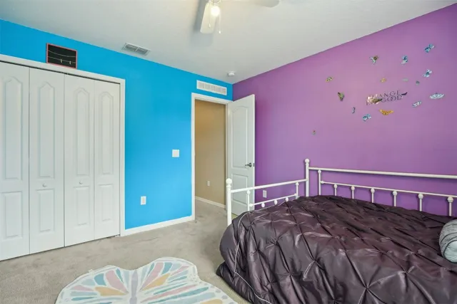 a bed sitting in a spacious bedroom next to a window