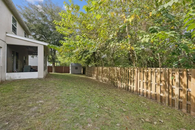 an aerial view of a house with a yard and large trees