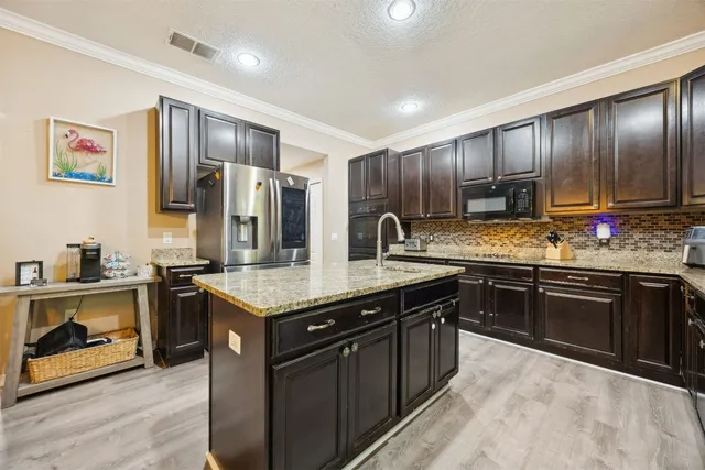 a kitchen with granite countertop a sink and a refrigerator