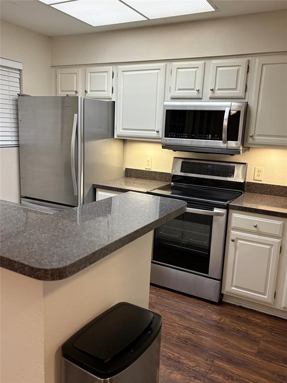 1720 Northeast Green Oaks Boulevard, Unit 104 Arlington, TX 76006 - Photo 3 of 13 a kitchen with granite countertop a stove and a microwave