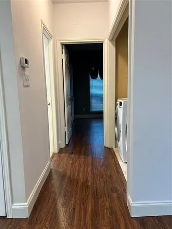 a view of a hallway with wooden floor
