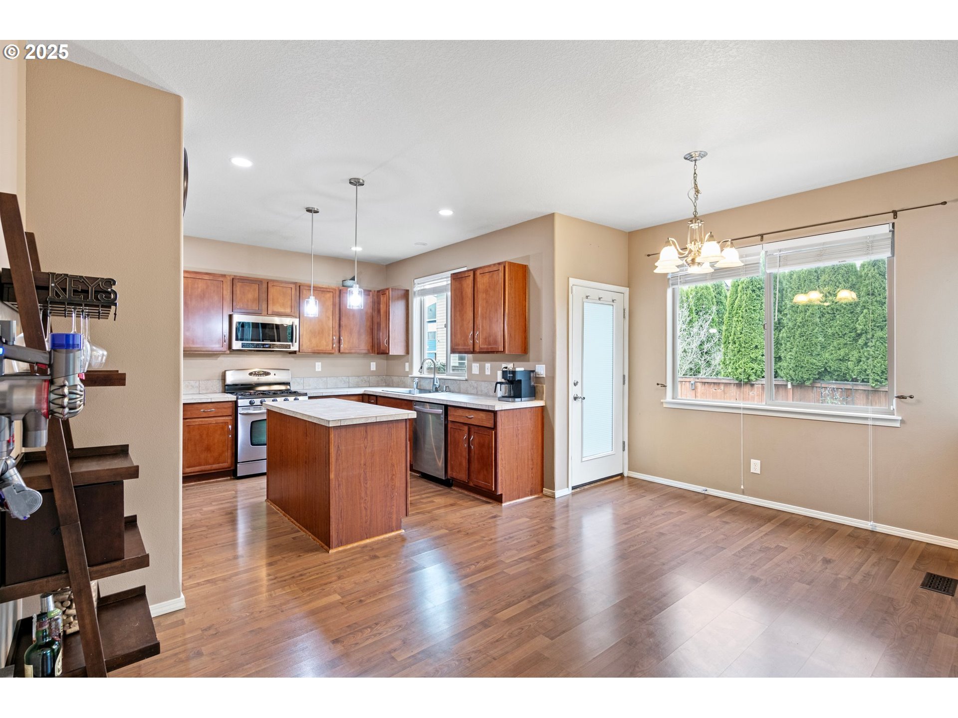 646 Raber Road Eugene, OR 97402 - Photo 14 of 44 a kitchen with stainless steel appliances granite countertop a refrigerator a sink dishwasher a stove and a dining table with wooden floor
