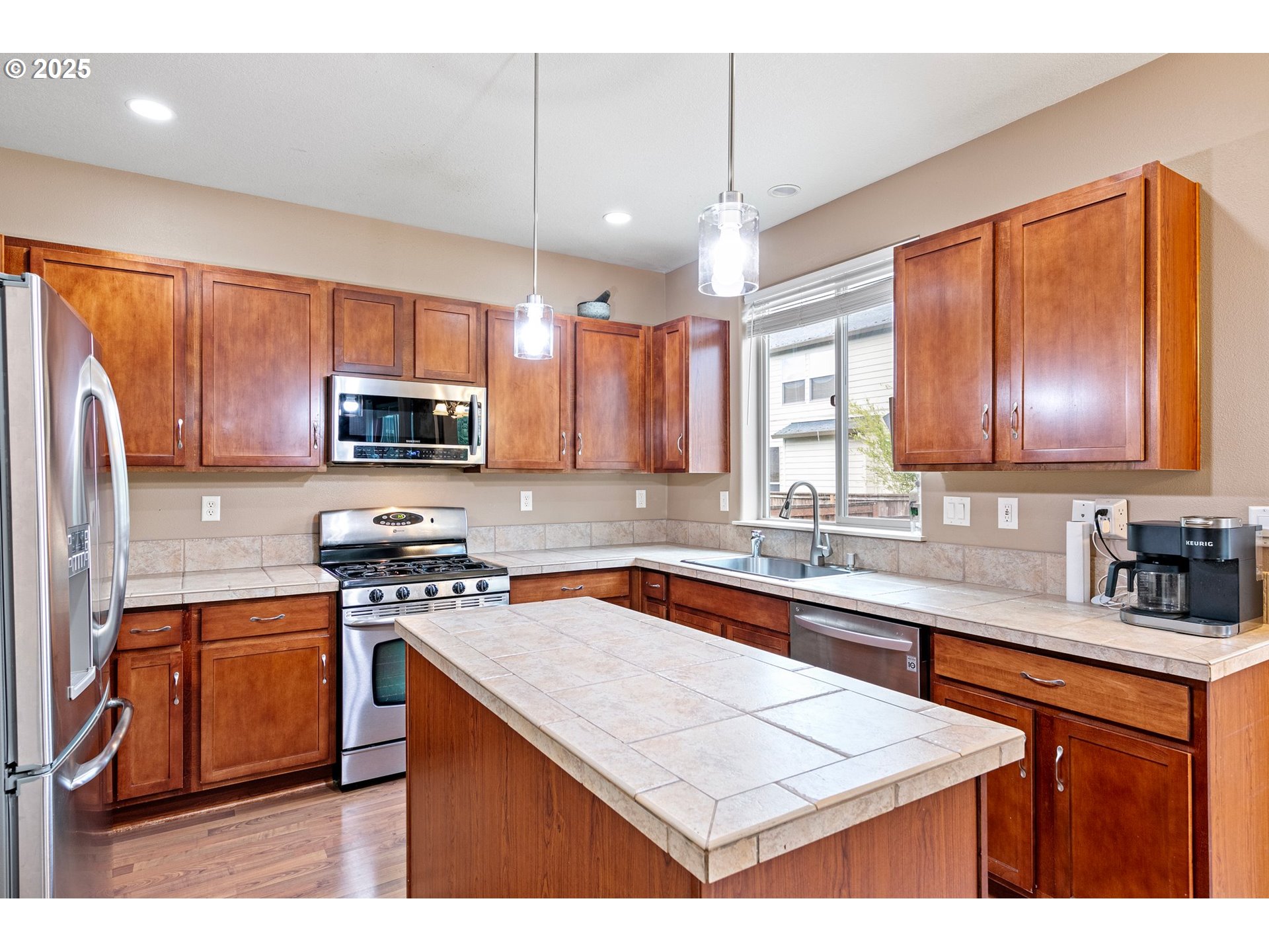 646 Raber Road Eugene, OR 97402 - Photo 16 of 44 a kitchen with stainless steel appliances granite countertop wooden cabinets a sink dishwasher a stove and a refrigerator with wooden floor