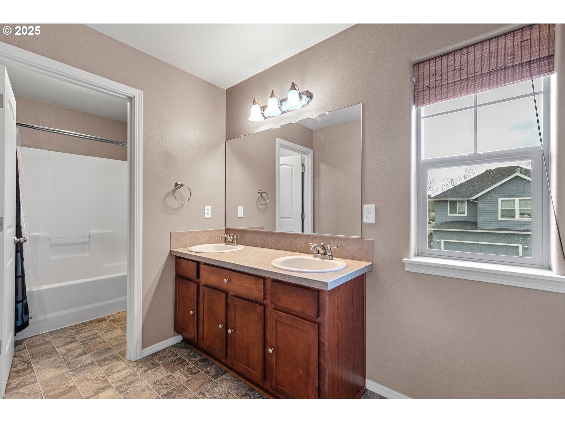 646 Raber Road Eugene, OR 97402 - Photo 33 of 44 a bathroom with a double vanity sink a mirror and a bathtub