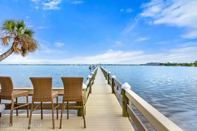 a kitchen with stainless steel appliances kitchen island granite countertop a table chairs in it and wooden floors