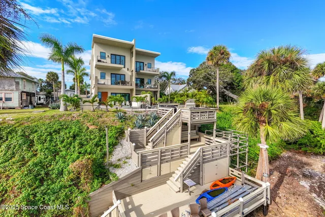 a living room with stainless steel appliances kitchen island furniture and a chandelier
