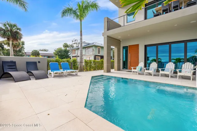 a view of a balcony with two chairs and a potted plant