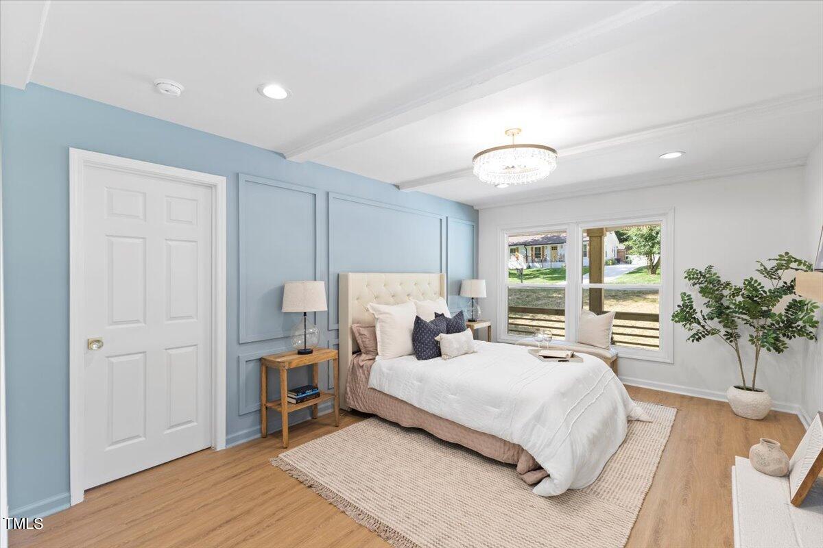 217 Brandon Court Raleigh, NC 27609 - Photo 14 of 30 a bedroom with a large bed and a chandelier