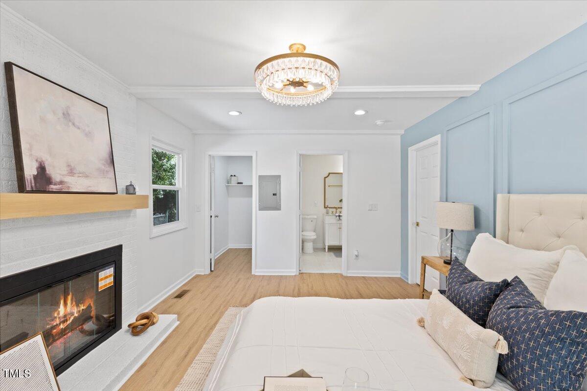 217 Brandon Court Raleigh, NC 27609 - Photo 15 of 30 a spacious bedroom with a bed and a fireplace