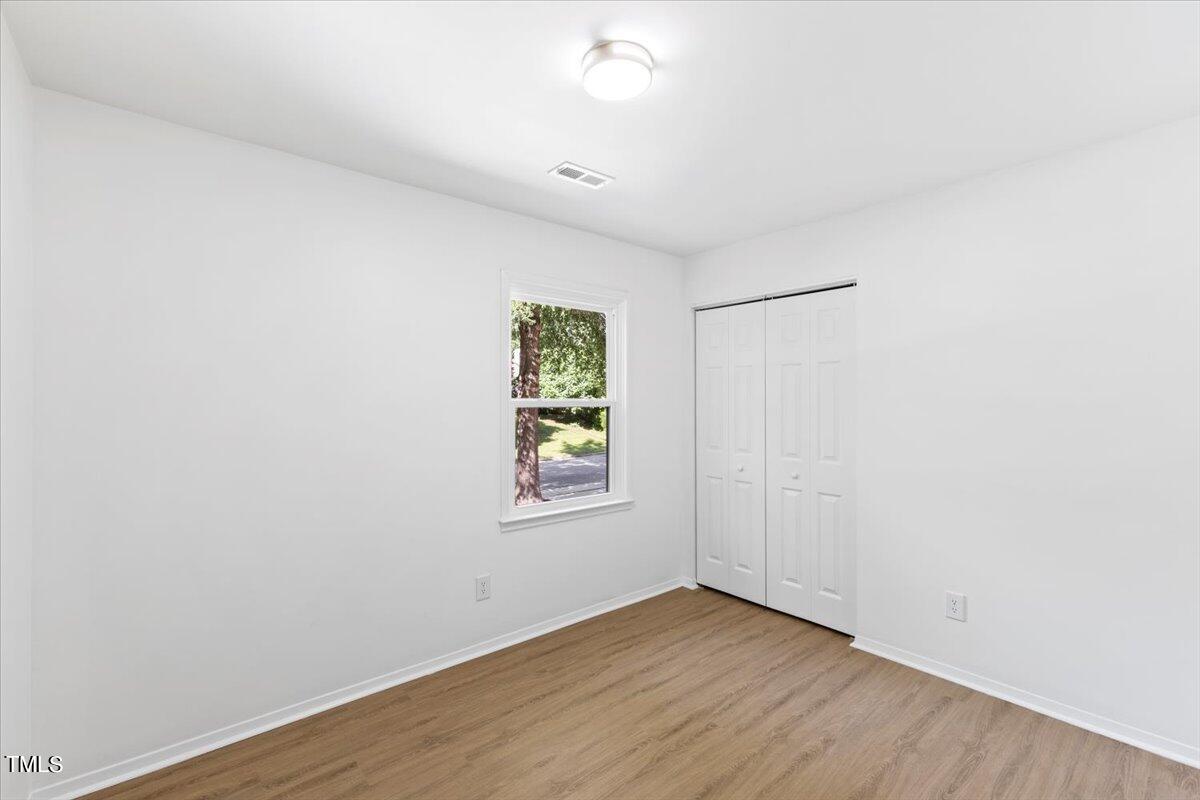 217 Brandon Court Raleigh, NC 27609 - Photo 26 of 30 an empty room with wooden floor and windows