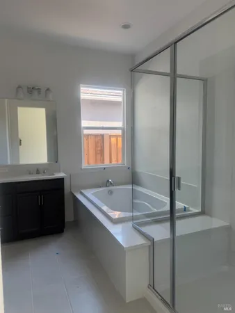 a bathroom with a tub a sink and a mirror