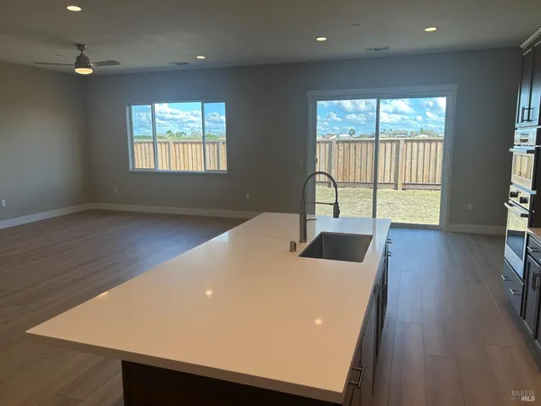 a kitchen with stainless steel appliances kitchen island granite countertop a refrigerator and a stove top oven