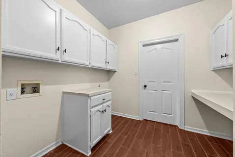 a kitchen with cabinets and wooden floor