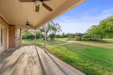 a view of swimming pool with a big yard and potted plants