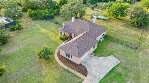 an aerial view of a house with a yard and lake view