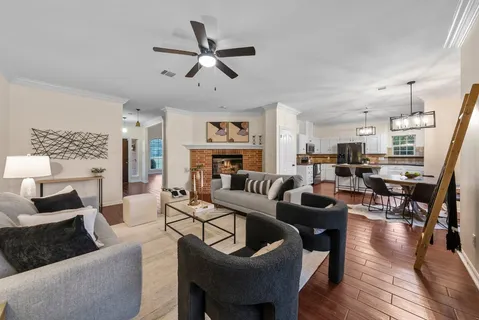 a living room with furniture kitchen view and a chandelier