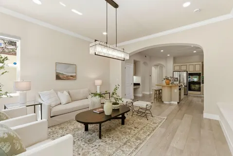 a living room with furniture a rug and kitchen view