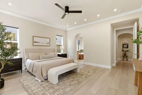 a spacious bedroom with a bed and a chandelier