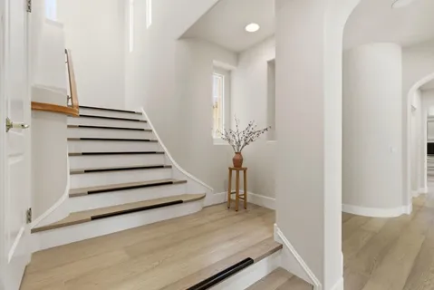 a view of a livingroom with wooden floor and stairs