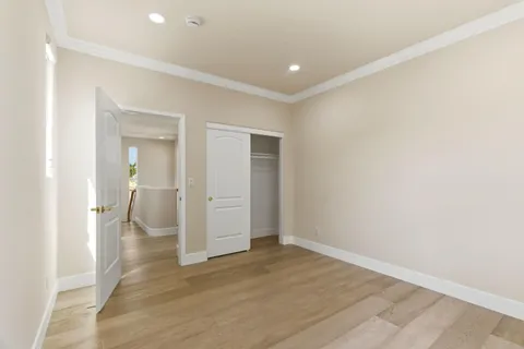an empty room with wooden floor and bathroom