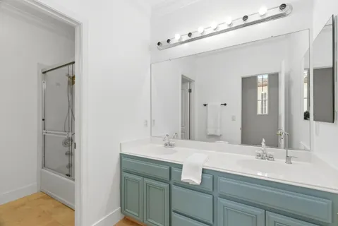 a bathroom with a sink double vanity granite tub shower and a mirror
