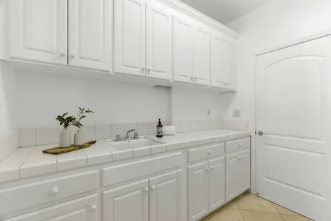 a kitchen with white cabinets and a sink