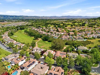 an aerial view of residential houses with outdoor space and trees
