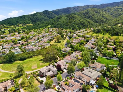 a view of a lush green field with mountains in the background